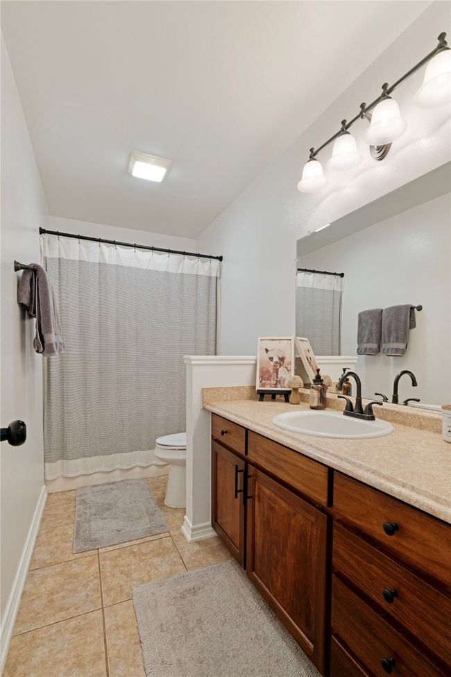 Bathroom featuring baseboards, vanity, tile patterned flooring, and toilet | Image 15