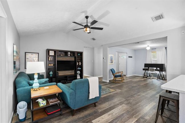 This open-concept living space features modern flooring and neutral walls, creating a bright and welcoming atmosphere. Perfect for relaxation and entertaining. | Image 14