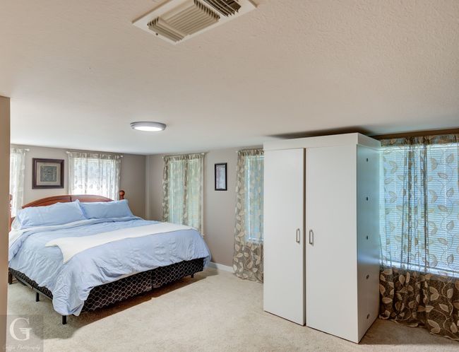 Carpeted bedroom featuring a textured ceiling and a closet | Image 16