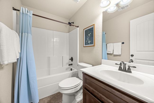 Bathroom with vanity, shower / bath combo, and a textured wall | Image 21