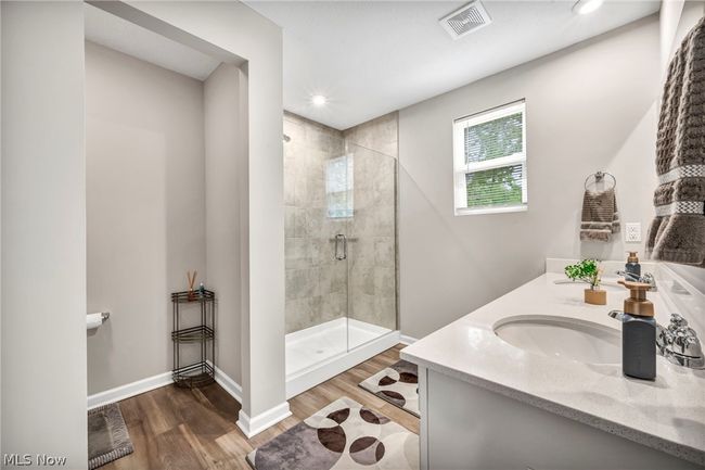 Bathroom featuring wood-type flooring, an enclosed shower, and vanity | Image 40