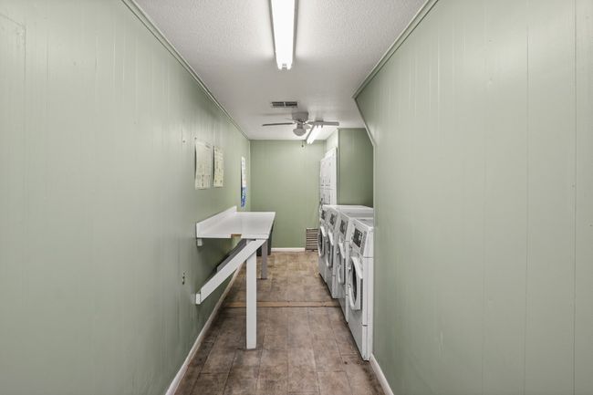 Washroom featuring washing machine and dryer, a ceiling fan, a textured ceiling, and wood walls | Image 34