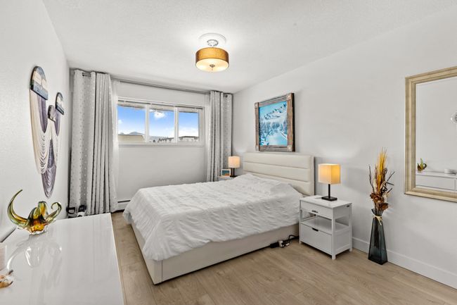 Bedroom featuring light wood finished floors, baseboards, and a baseboard radiator | Image 19