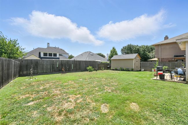 Fenced backyard with a storage shed | Image 4