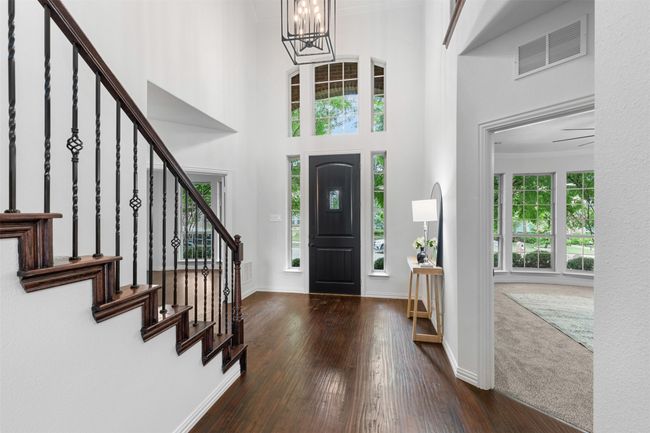 Entrance foyer featuring hardwood / wood-style flooring, a chandelier, visible vents, baseboards, and stairs | Image 4
