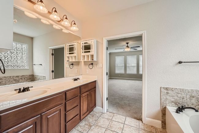 Bathroom with a garden tub, a sink, a ceiling fan, and tile patterned floors | Image 22