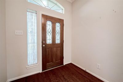 A pretty leaded glass door with sidelight and arched window allows the natural light to flow into the space! | Image 2