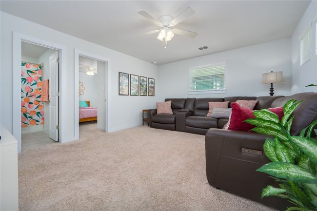Carpeted living area featuring a ceiling fan and baseboards | Image 18
