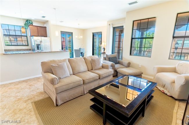 Living room with visible vents, baseboards, and a notable chandelier | Image 9