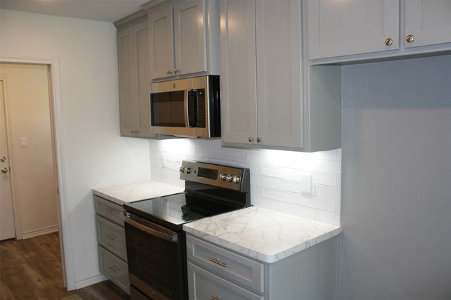 Kitchen featuring appliances with stainless steel finishes, gray cabinetry, and backsplash | Image 4