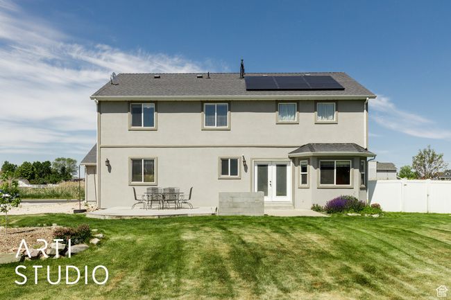 Rear view of property with french doors, a patio area, solar panels, and stucco siding | Image 37