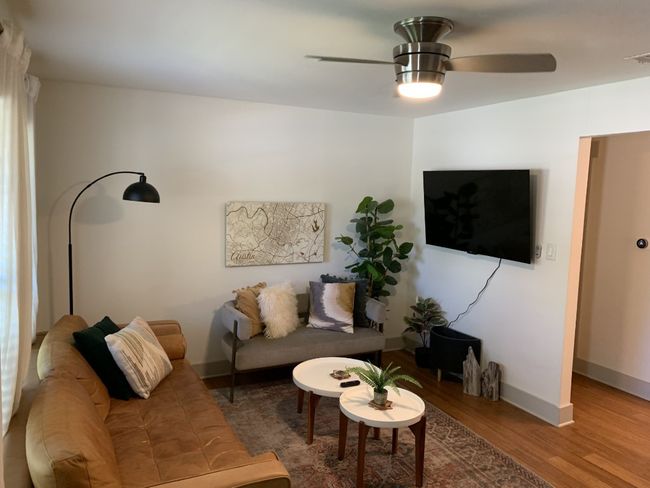 Living room with ceiling fan, wood finished floors, and baseboards | Image 5