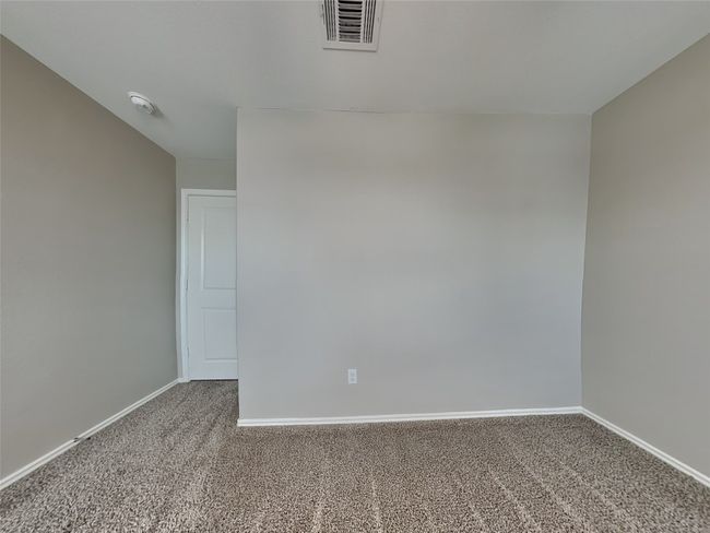 Carpeted spare room featuring baseboards and a smoke detector | Image 9