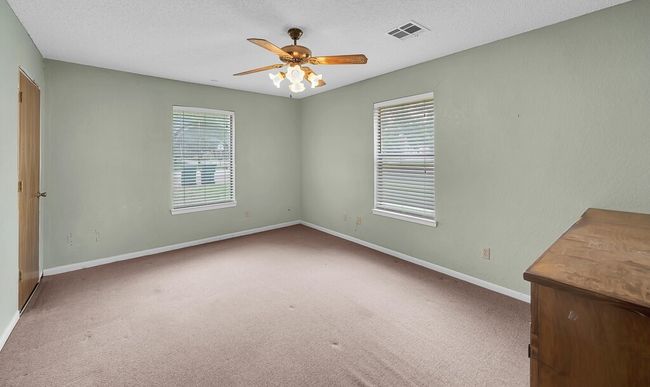 Carpeted empty room with baseboards, ceiling fan, and a textured ceiling | Image 12