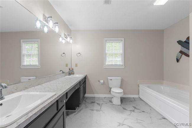 Full bathroom featuring a healthy amount of sunlight, a sink, and toilet | Image 25