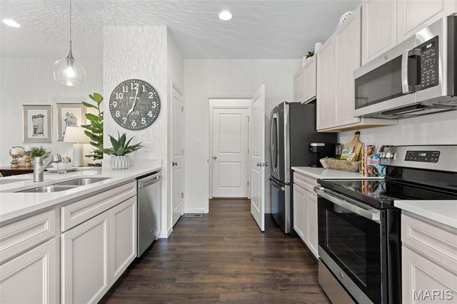 Kitchen featuring appliances with stainless steel finishes, a sink, light countertops, dark wood finished floors, and recessed lighting | Image 18