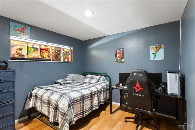Bedroom featuring wood finished floors and an office area | Image 10