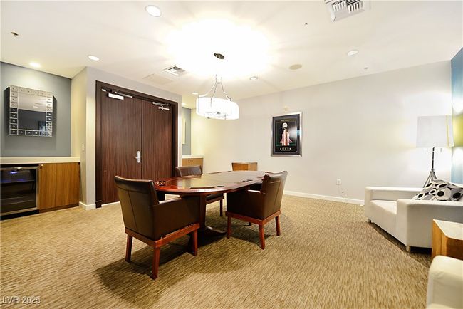 Recreation room with light colored carpet, baseboards, wine cooler, and visible vents | Image 42