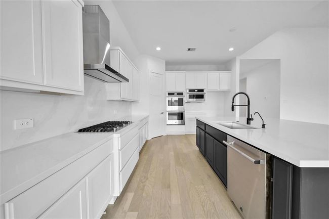 Upgraded kitchen with a sleek JennAir stainless steel hood and appliance package, blending style and functionality seamlessly. | Image 19