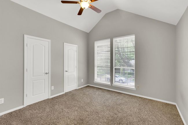 Unfurnished bedroom featuring lofted ceiling, baseboards, carpet, and multiple windows | Image 22