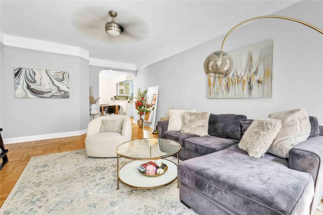 Living area with a ceiling fan, baseboards, and arched walkways | Image 16