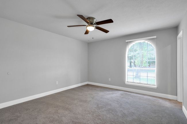 Carpeted empty room featuring ceiling fan and baseboards | Image 14