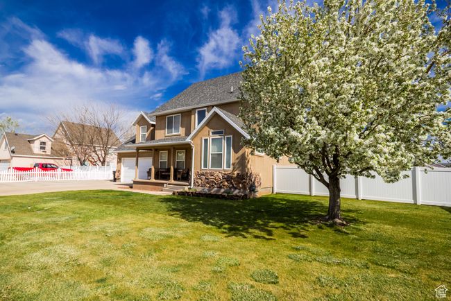 Back of property featuring fence, a lawn, stucco siding, and stone siding | Image 28