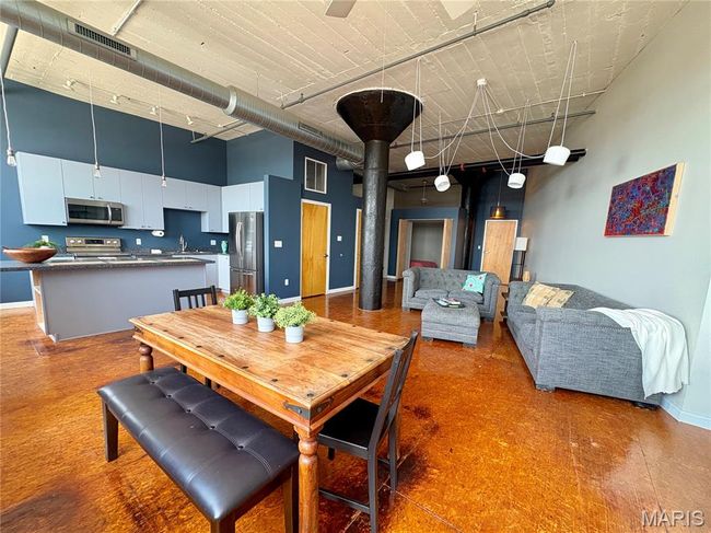 Dining area with a towering ceiling and baseboards | Image 10