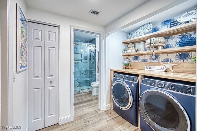 Laundry area with washing machine and clothes dryer and light wood finished floors | Image 34