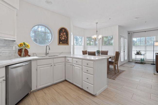 Huge kitchen, with breakfast bar, looking into the dining room area with beautiful new floors. | Image 12