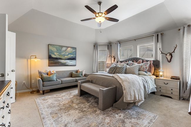 Bedroom featuring a ceiling fan, baseboards, vaulted ceiling, and light colored carpet | Image 15
