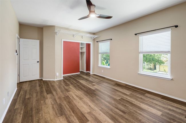 Unfurnished bedroom with wood finished floors, ceiling fan, baseboards, and a closet | Image 19