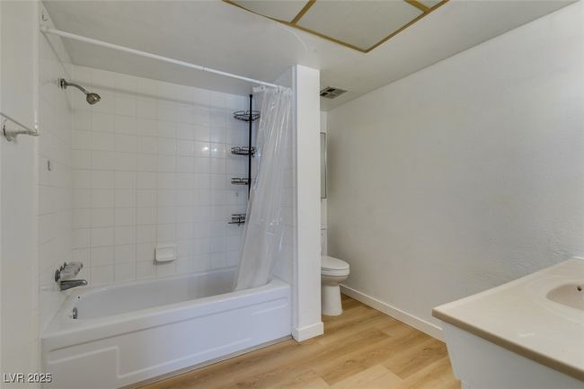 Bathroom with shower / tub combo with curtain, wood finished floors, and vanity | Image 34