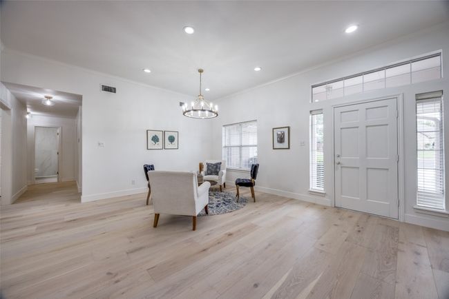 Dining space with crown molding, light wood finished floors, a chandelier, and recessed lighting | Image 5