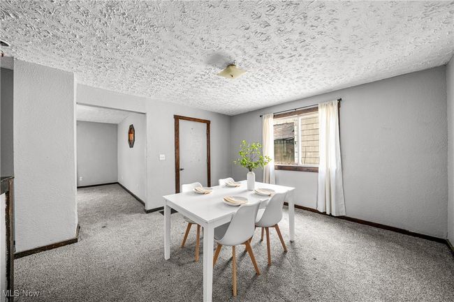 Carpeted dining area featuring baseboards and a textured ceiling | Image 8
