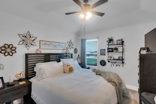 Carpeted bedroom featuring a ceiling fan and lofted ceiling | Image 21