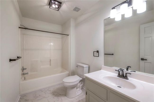 Full bath featuring marble look tile flooring, vanity, and shower / washtub combination | Image 20