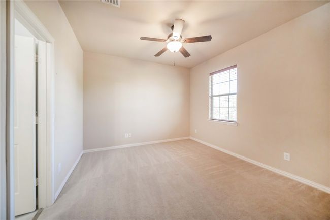 Empty room with a ceiling fan and light carpet | Image 26