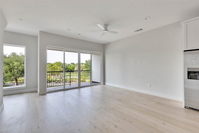 Unfurnished living room with ceiling fan, light wood-style flooring, plenty of natural light, and baseboards | Image 19
