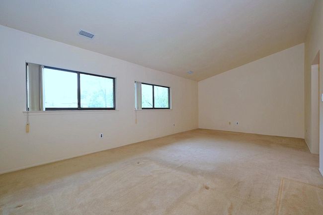 Empty room featuring light colored carpet, lofted ceiling, and visible vents | Image 10