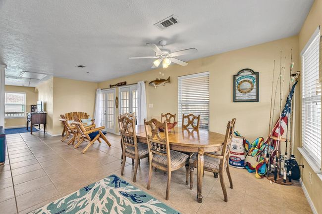 The dining area is at the side of the kitchen and opens to a seating area that accesses the French doors. | Image 6