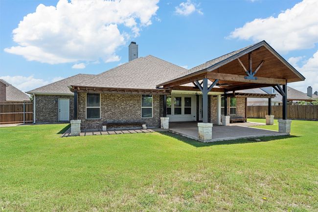 Back of property featuring a patio area, brick siding, roof with shingles, and a fenced backyard | Image 34