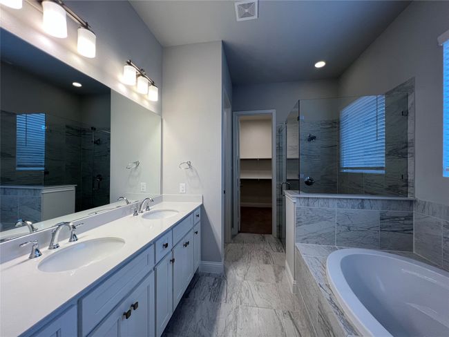 Bathroom featuring a shower stall, a garden tub, double vanity, baseboards, and recessed lighting | Image 10