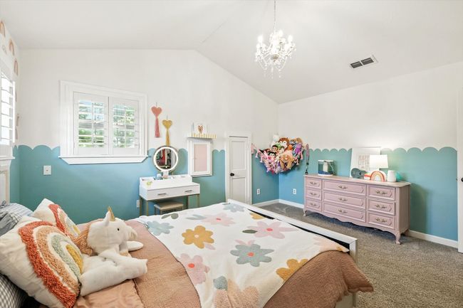 Bedroom with carpet floors, lofted ceiling, and a chandelier | Image 28
