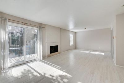 Unfurnished living room featuring a large fireplace and light wood-type flooring | Image 3