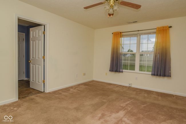 spare room with carpet flooring, a ceiling fan, baseboards, and a textured ceiling | Image 7