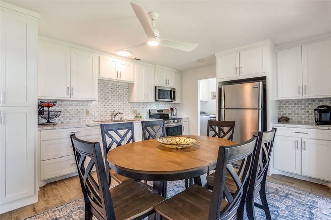 Dining space featuring a ceiling fan, light wood-style flooring, and washer / clothes dryer | Image 9