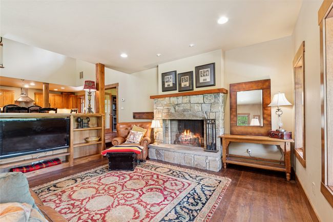 Living area with a stone fireplace, wood flooring, and recessed lighting | Image 14