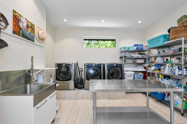 Laundry room with cabinet space, washer and dryer, recessed lighting, and light wood-style floors | Image 84