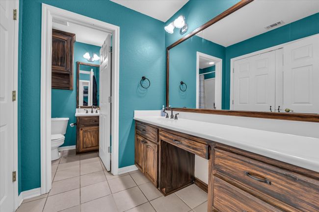 Bathroom with toilet, tile patterned floors, vanity, and baseboards | Image 17
